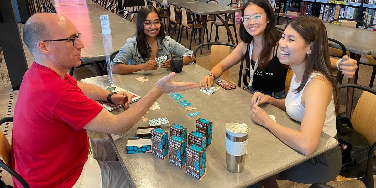 Brian with three other people at a board game cafe