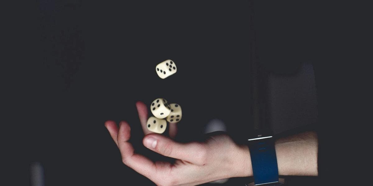 A hand flipping several dice